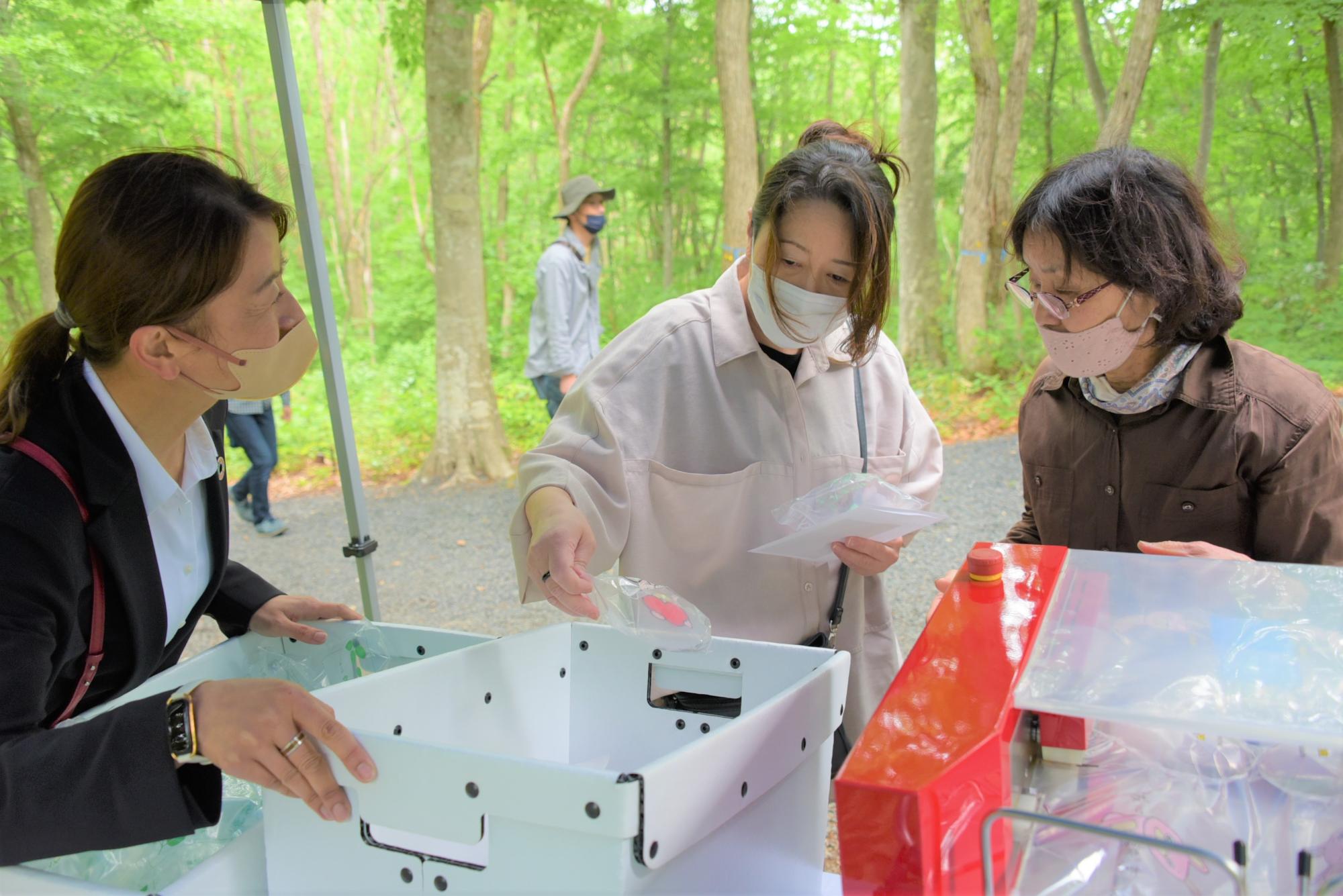 空気神社の空気が詰まったエアピロンをプレゼントする川上産業株式会社ブース