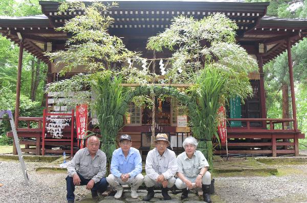 完成した茅の輪の前で記念写真の画像