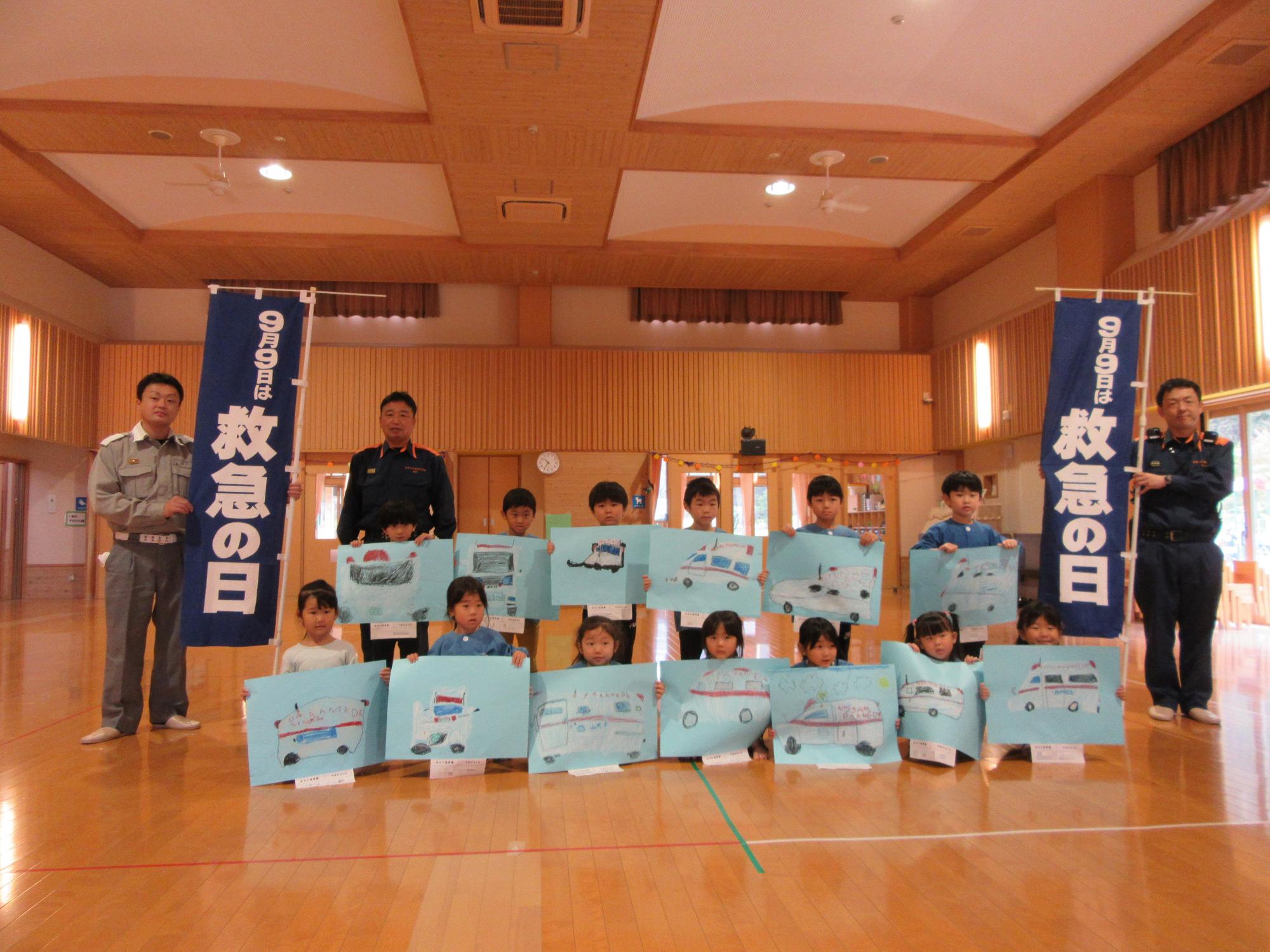 救急車の絵と一緒に5歳児 やまがら組