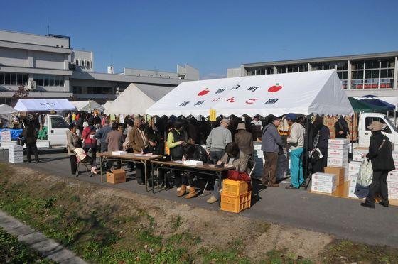 箱入りりんごを買うために賑わう様子の写真