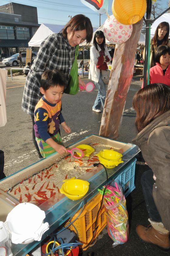 親子で金魚すくいを楽しんでいる様子の写真