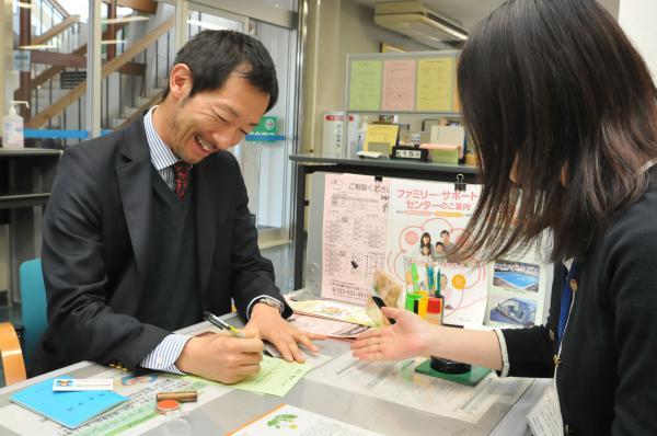 役場窓口で住所移転の手続きを行う村尾氏の写真