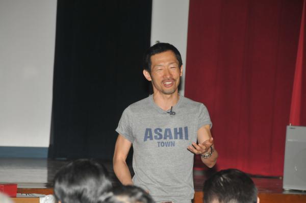ASAHI TOWNのロゴの入ったTシャツを着た村尾氏の写真