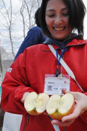 雪室りんごを手に持つ女性の写真