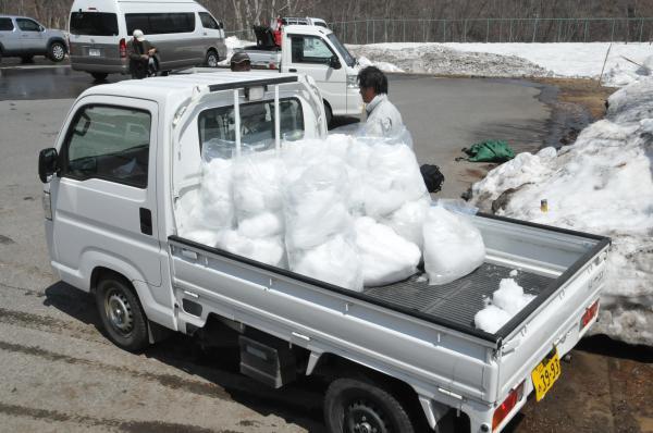 空気まつり用に保存する雪を運ぶ軽トラックの写真