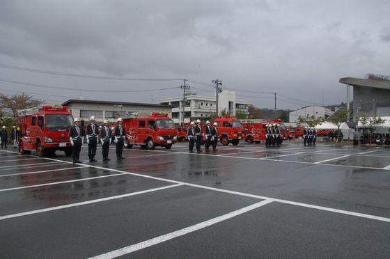 雨の中演習する消防隊員の写真