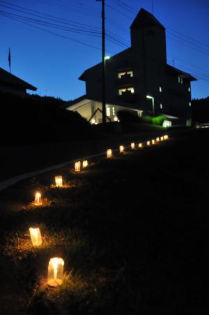 夜空を背景にAsahi自然観へと続く道路に沿って置かれた沢山の火を灯すキャンドルの写真