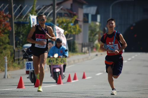 太郎橋でタッチの差でタスキを受け取った選手たちが走っている写真