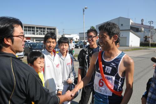 ゴール後にチームスタッフと喜びの握手を交わす長岡選手の写真