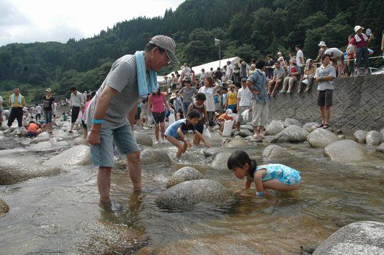 魚をつかみ取りする参加者の写真1