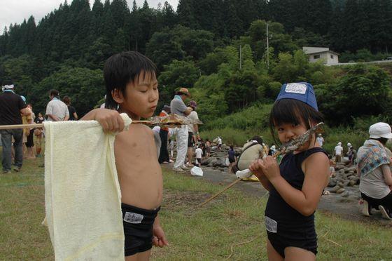 魚の塩焼きを食べている参加者の写真