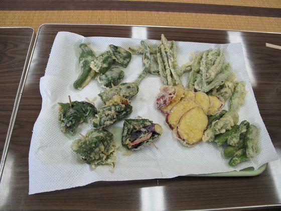 テーブルの上にある収穫祭でふるまわれた菜種油で揚げた地元産の野菜の天ぷらの写真