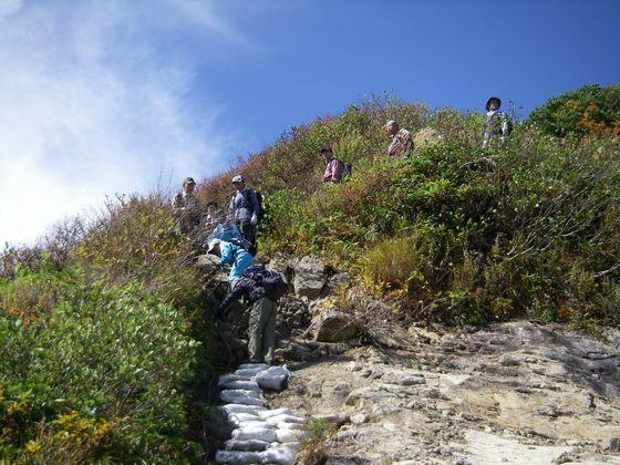 危険箇所で引率者の指導により安全に登山を楽しむ様子の写真
