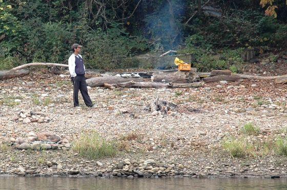 地上で岡崎さんのご家族の方が火をおこしてアユの到着を待っている写真