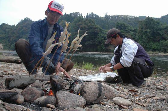 とれたアユを岡崎さん親子が塩焼きにしている写真