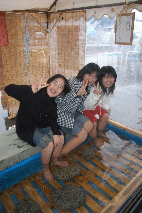 足湯コーナーで3人の女の子がピースしている写真