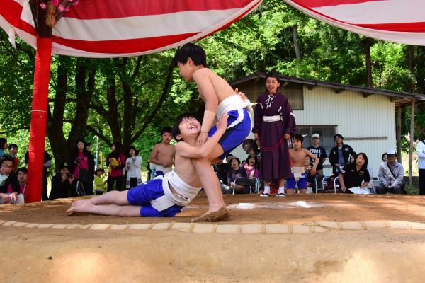 取り組み中に腿から下を土俵につき、相手にしがみついている写真