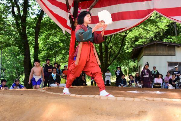 呼び出しが土俵を一周して最初の対戦力士を紹介している写真