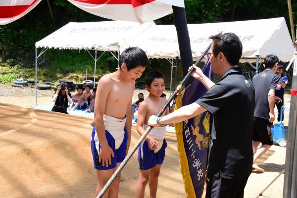 両軍の同点優勝で優勝旗を渡す様子の写真