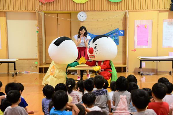 おこめんジャーグリーンとリーダーが腕相撲で真剣に勝負している様子の写真