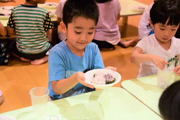 園児が作ったかわいい真ん丸のおにぎりをお皿にのせている様子の写真