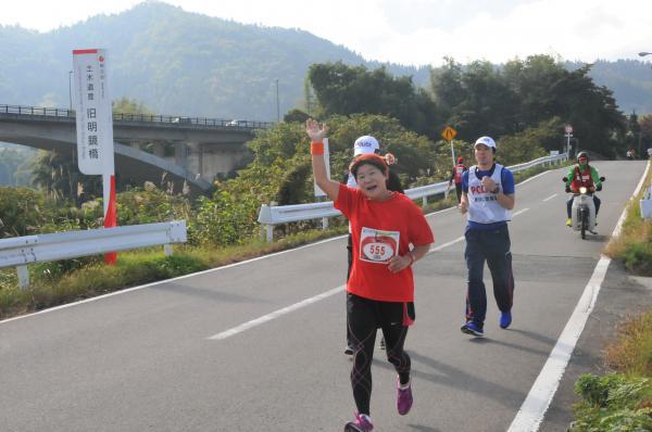 手を上げて走る女性選手の写真