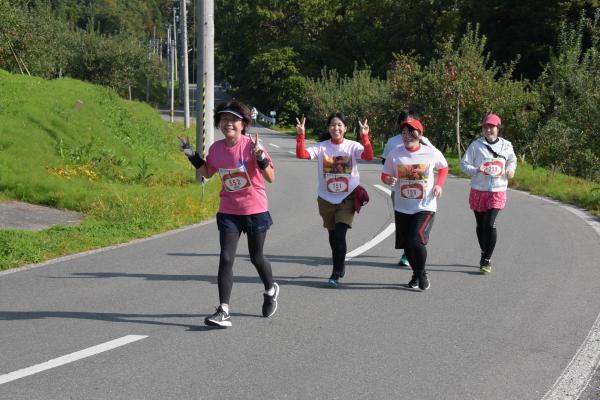 ピースサインをしながら走る女性選手たちの写真