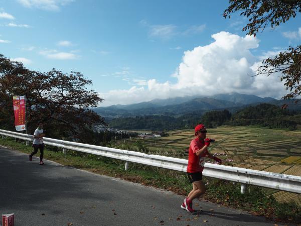 日本棚田百選の「椹平の棚田」が一望できる「一本松公園」で走る選手たちの写真