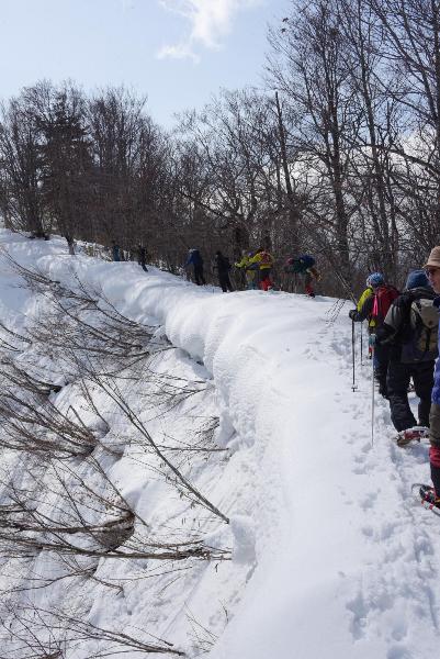 雪庇を横目に登る参加者たち