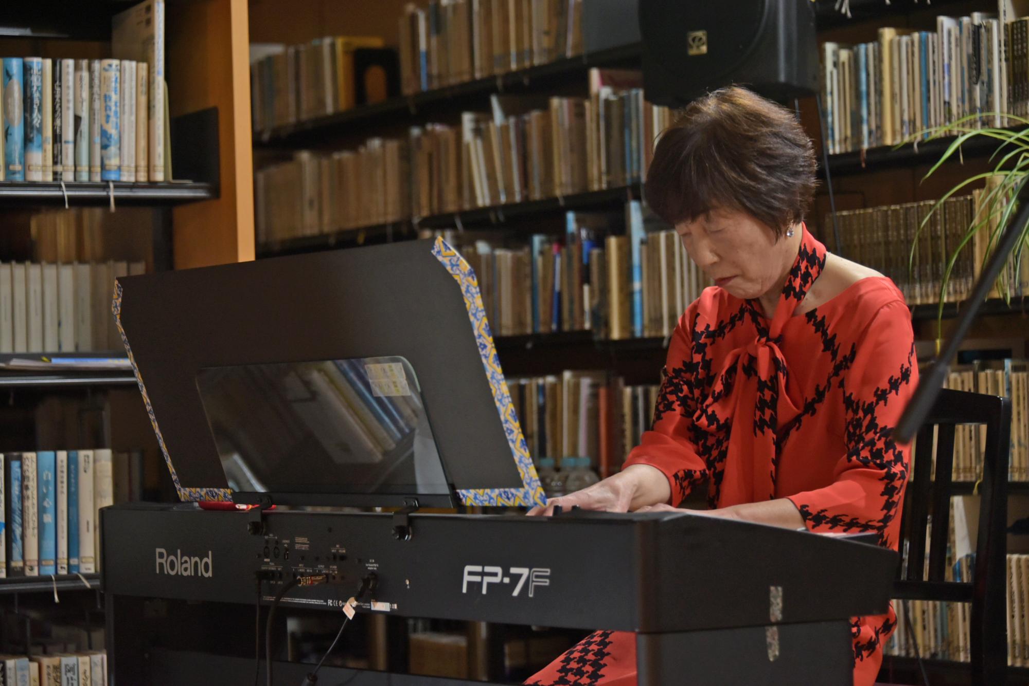 朗読に合わせピアノを弾く田中さん