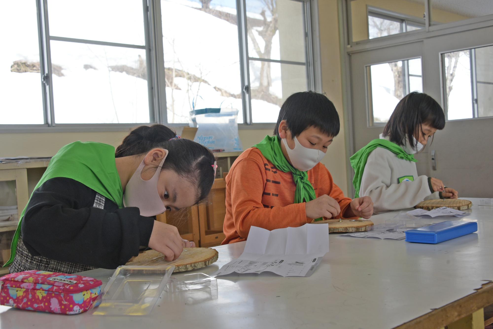 時計を木に取り付ける子どもたち