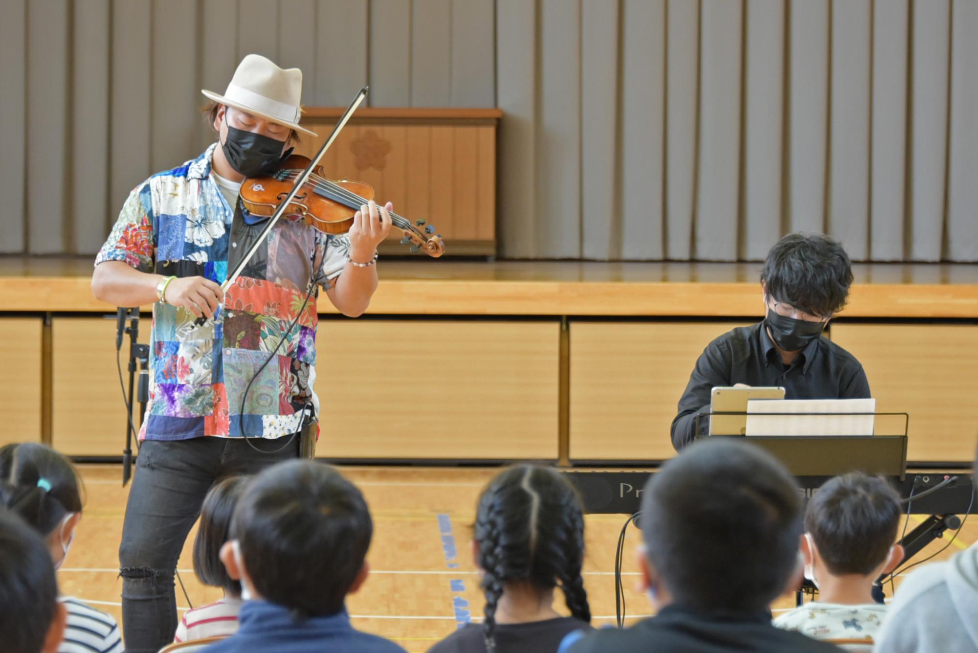 児童の前で演奏する2人