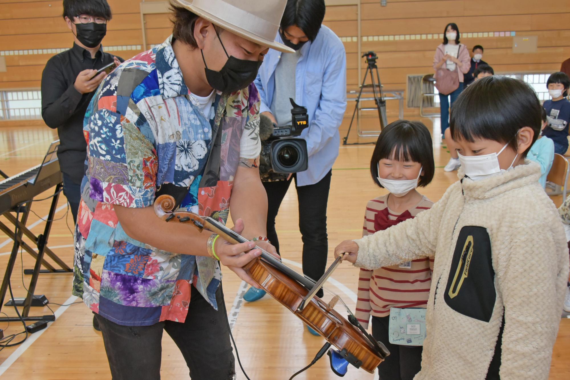 弓を使って鳴らす子どもたち