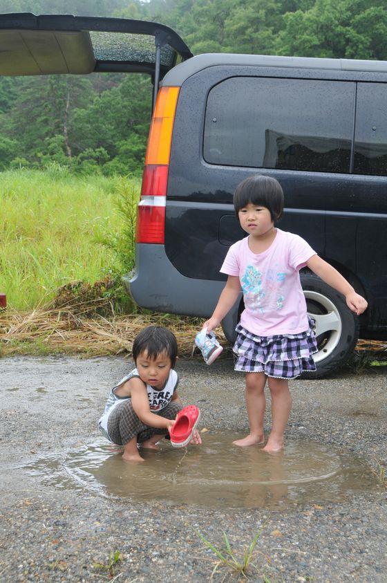 水たまりに足を浸す二人の子どもの写真