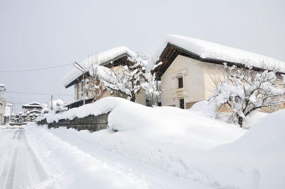 雪に覆われた鈴木酒造の酒蔵の外観の写真