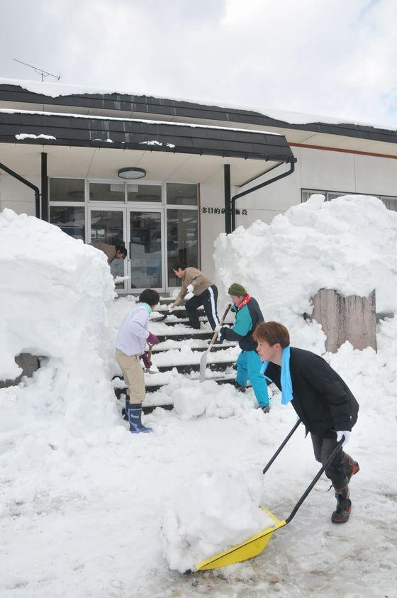 雪かき作業が進むにつれて階段が見えてきてる様子の写真