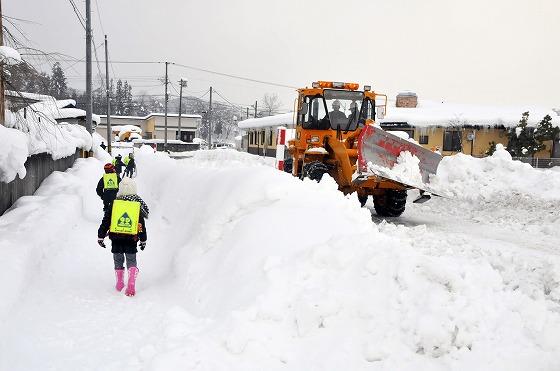 大雪で除雪車が出動する様子の写真