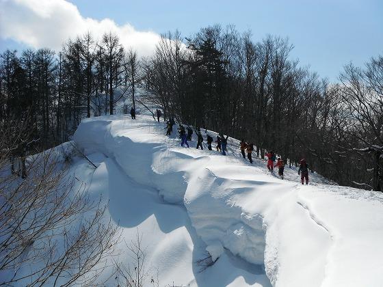 ダイナミックな雪庇を進む参加者の写真