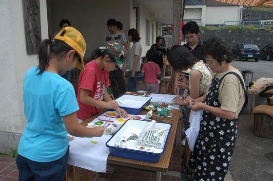 上郷採祭の会場旧上郷小学校の入り口付近で絞り染めハンカチ作りをするの親子たちの写真