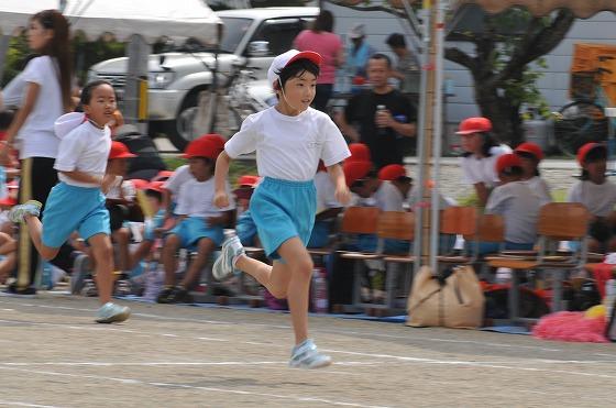 ゴールに向かって走る70メートル走に参加した低学年の男児生徒と後を追う女児生徒の写真