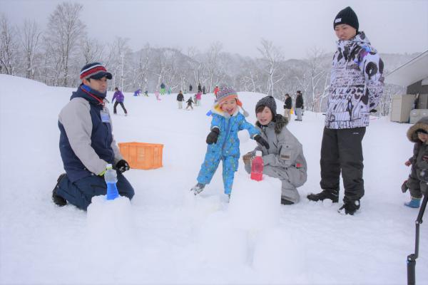 雪玉を投げる男の子とお母さんとお父さんの写真