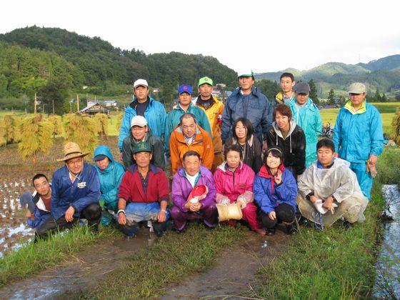 能中・椹平の棚田で行われた稲刈り体験ツアー参加者の集合写真1