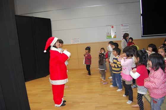 平成25年12月7日、創遊館で開催されたクリスマスこどものつどいで、サンタに扮した出演者と一緒に立つ子どもたちの写真