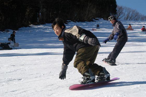 スノーボードで滑る子どもの写真1