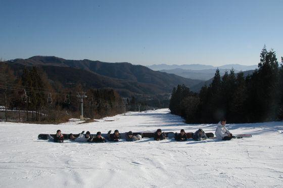 地元の中学生達が雪原に座り並ぶ写真