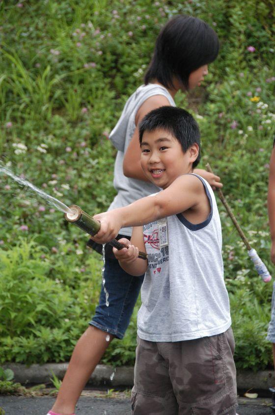 水鉄砲で遊んでいる男の子の写真