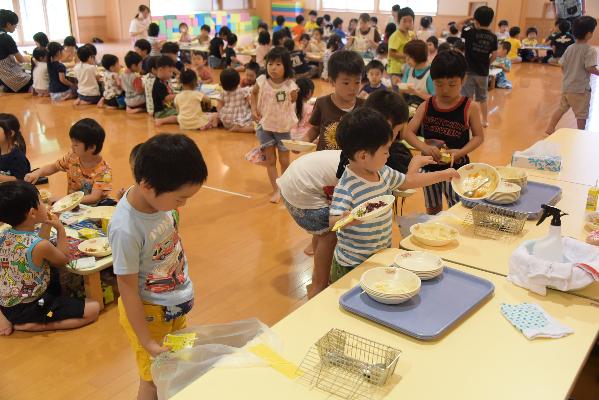 食べ終わった食器を片づけている園児たちの写真