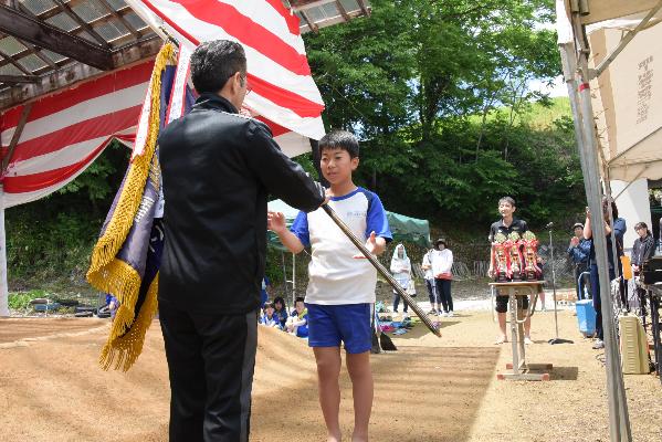 優勝した東方の横綱に優勝旗を渡す様子の写真