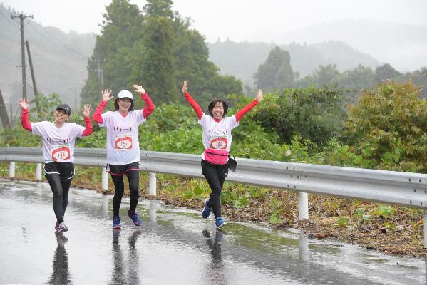 ピースサインをしながら走る女性選手たちの写真