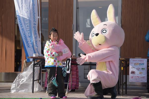 じゃんけんに勝ち、商品を受けとる少女の写真